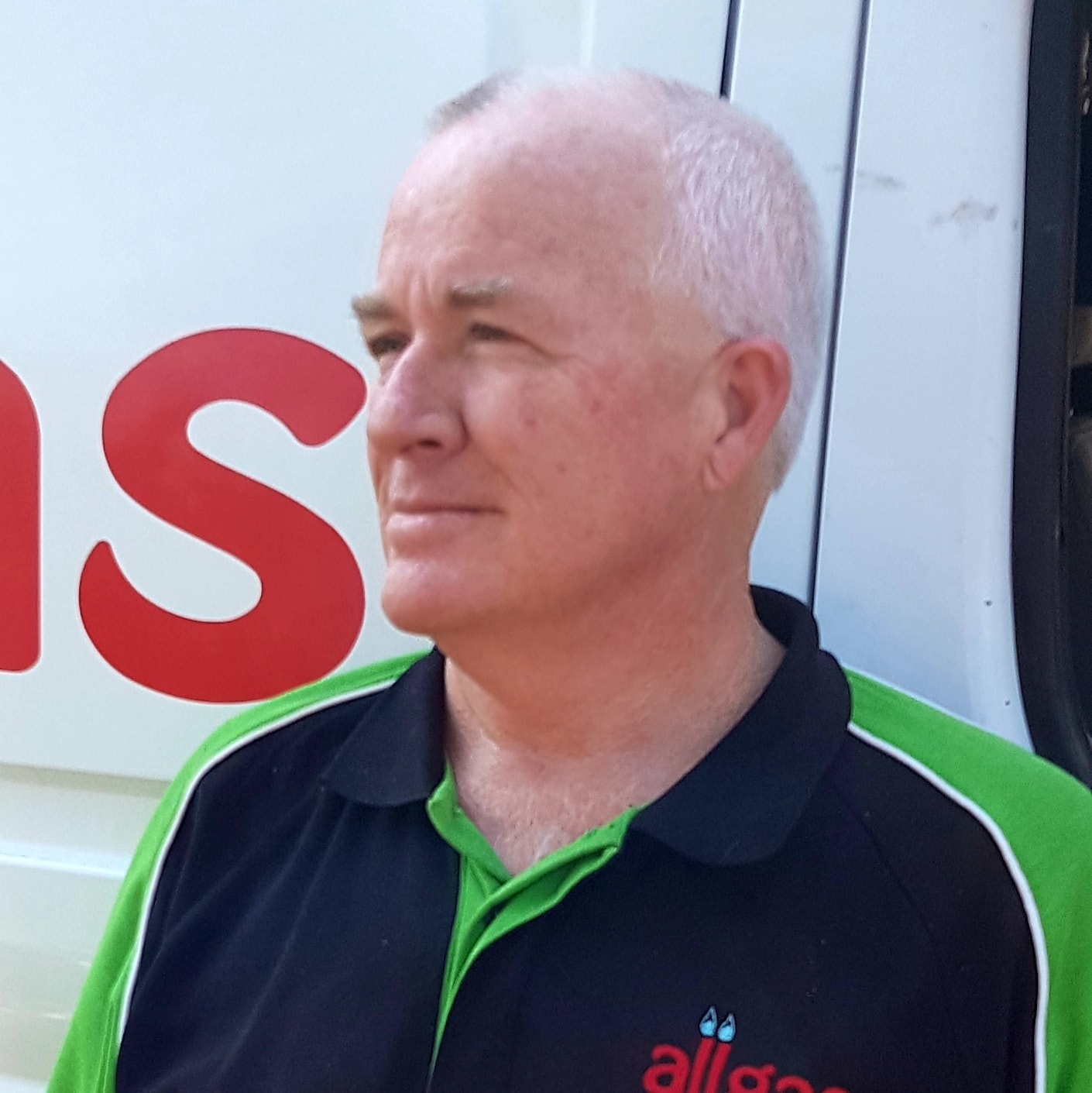 Glenn, the gasfitter behind Allgas Appliance Repairs, in his work polo beside the van